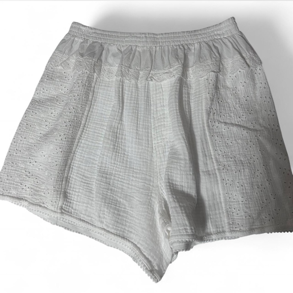 Free People white eyelet shorts with elastic waistband and pockets.